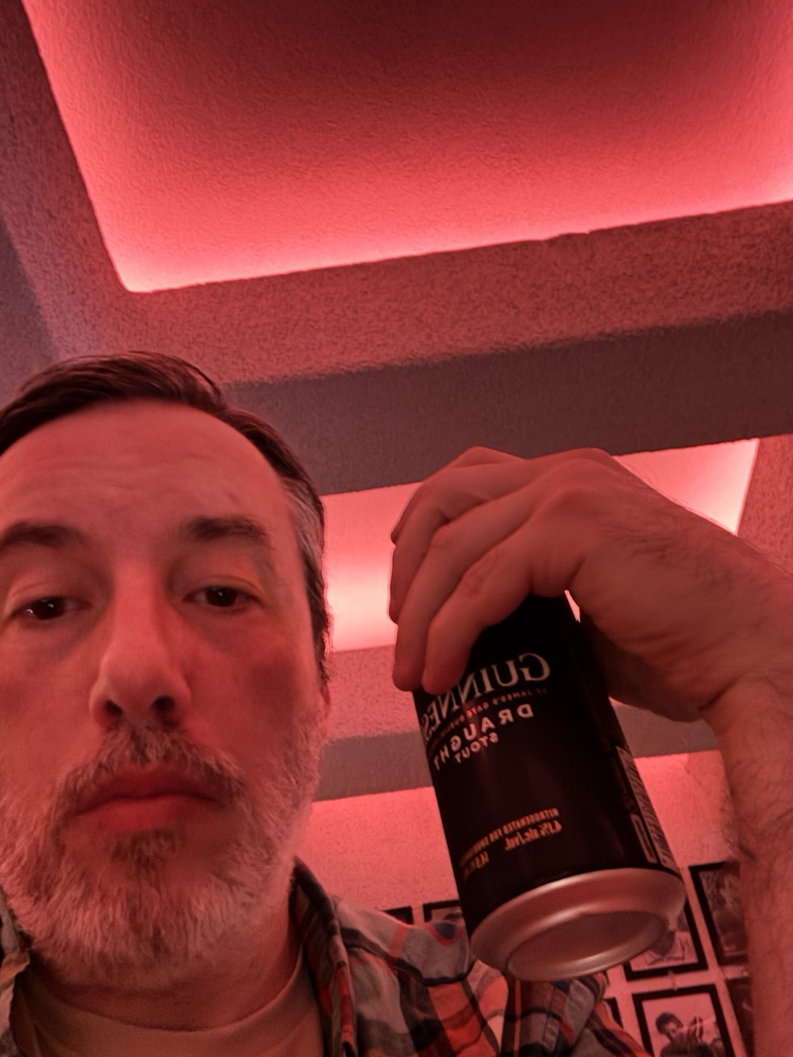 selfie with a beer in hand, looking up, all bathed in a red glow