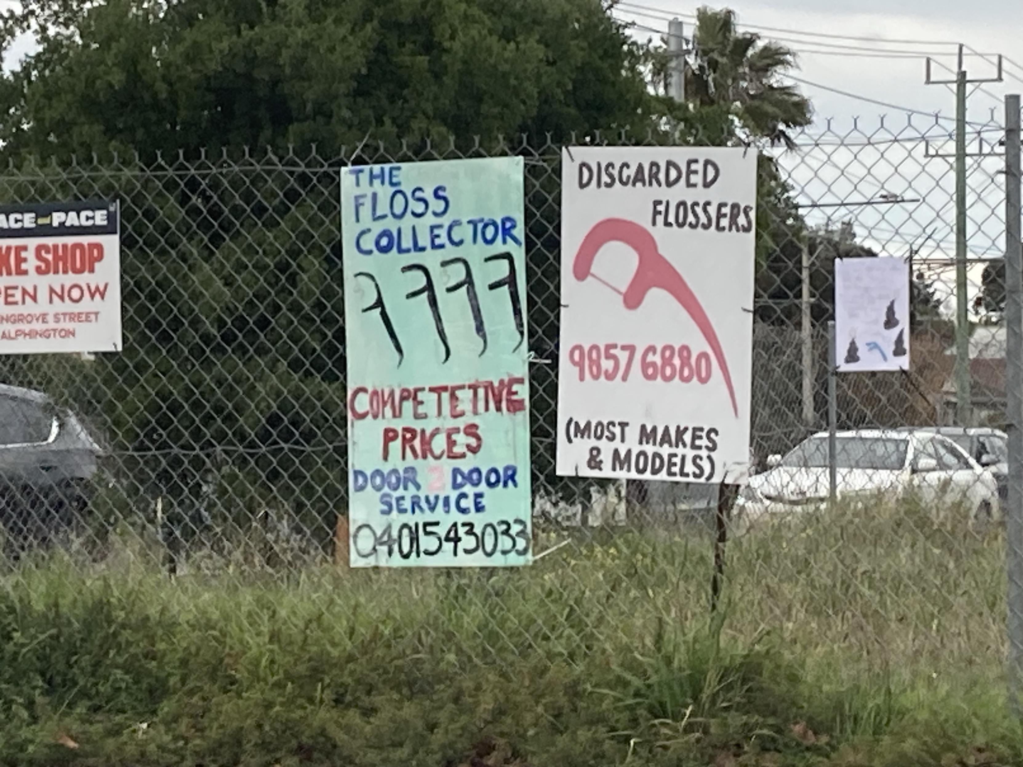 Hand painted signs posted on a Melbourne road, advertising used dental floss collection services