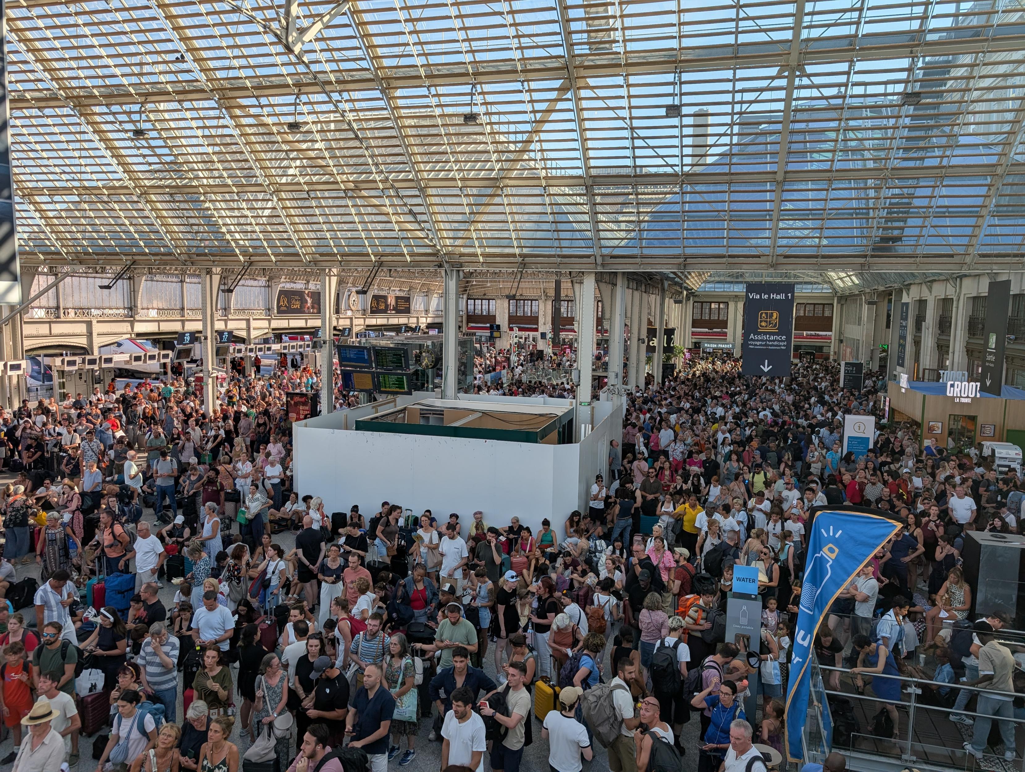 A dense crowd in Gare de Lyon Hall 2 seen from above, with a useless block in the middle surrounded by walls.