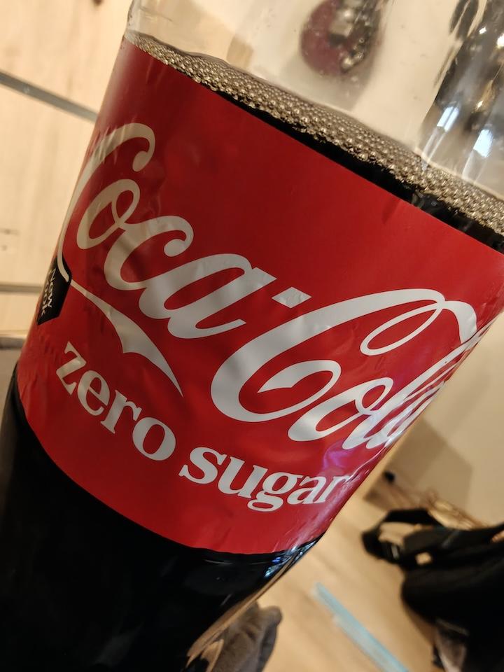 picture of a coca cola bottle in classic white-on-red colors, with the only thing distinguishing it from cola-with-sugar is the 'zero sugar' text on the label.