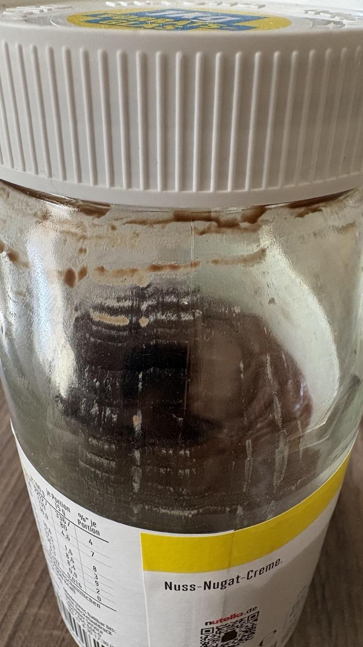 Ein Glas nutella von der Seite, es ist halbleer und es klebt fast keine Schokomasse an den Glaswänden