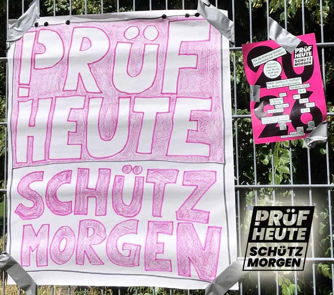Da hat sich Jemand viel Mühe gemacht und das Logo von PRÜF in Rosa auf weißem Grund nachgemalt. 
"PRÜF
HEUTE
SCHÜTZ
MORGEN"
Das "P" von PRÜF besteht aus einem Ausrufezeichen und einem passenden Bogen am oberen Ende.
Rechts hängt noch der Flyer mit den nächsten Veranstaltungen in Stuttgart am Zaun