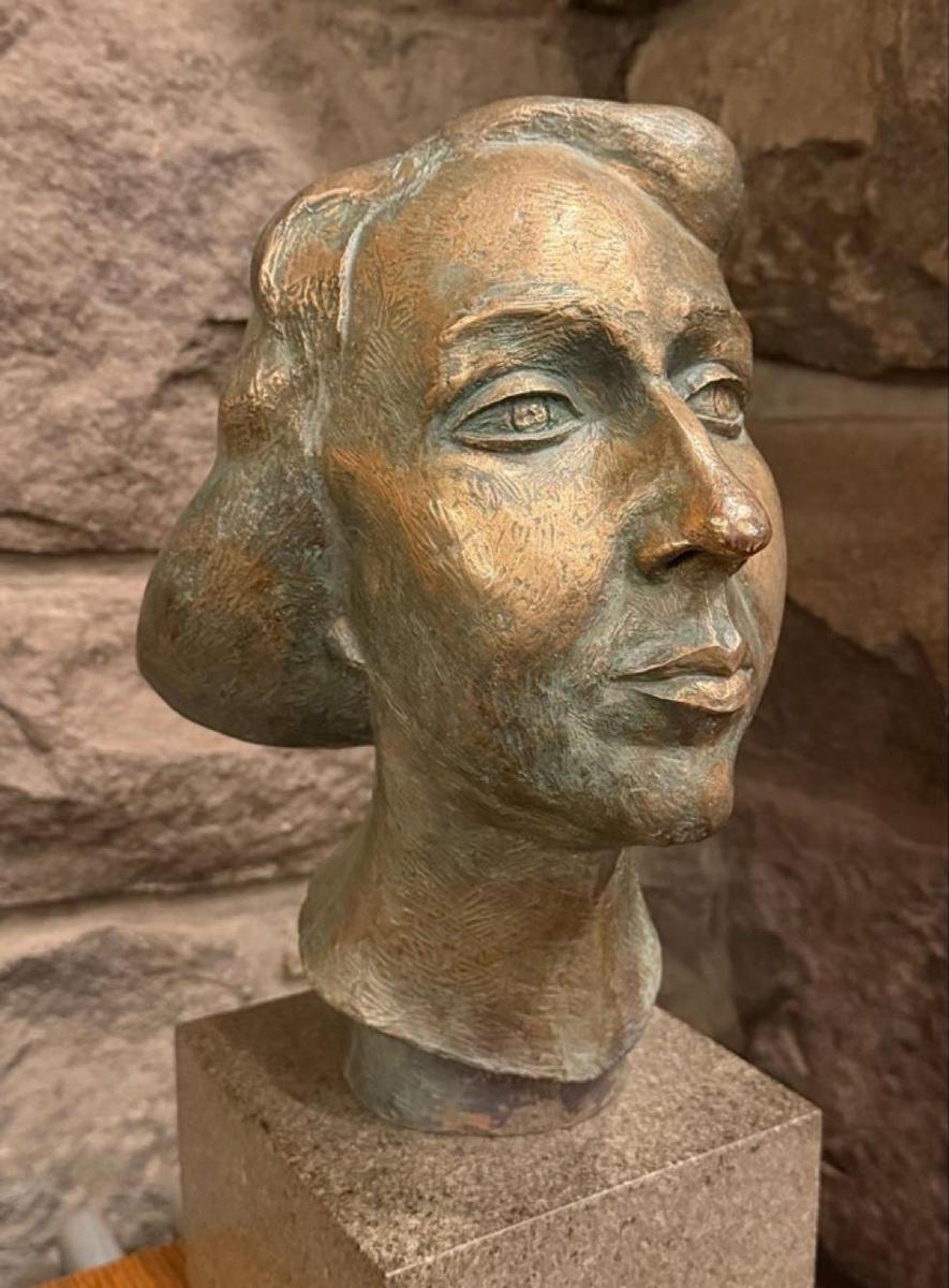 A sculpure of a woman's head. Maybe bronze.