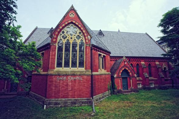 Brick chapel with stained glass windows near the 1/3 vertical line,  a tree to the left and an extension to the right
