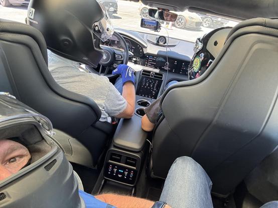 View from the back seat of Porsche Taycan at Autocross with crash helmets.