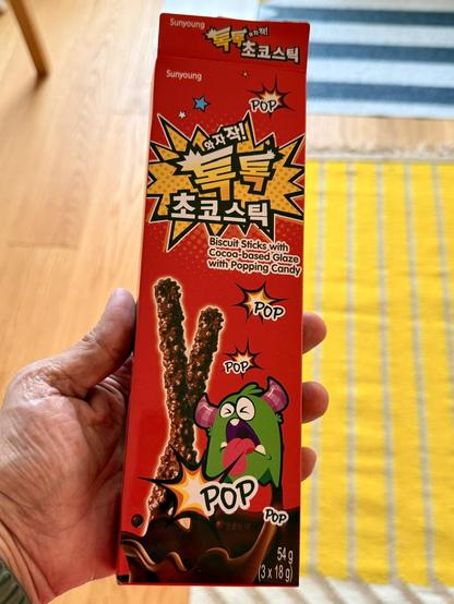A red box of candy with Korean writing and a green monster with its tongue out