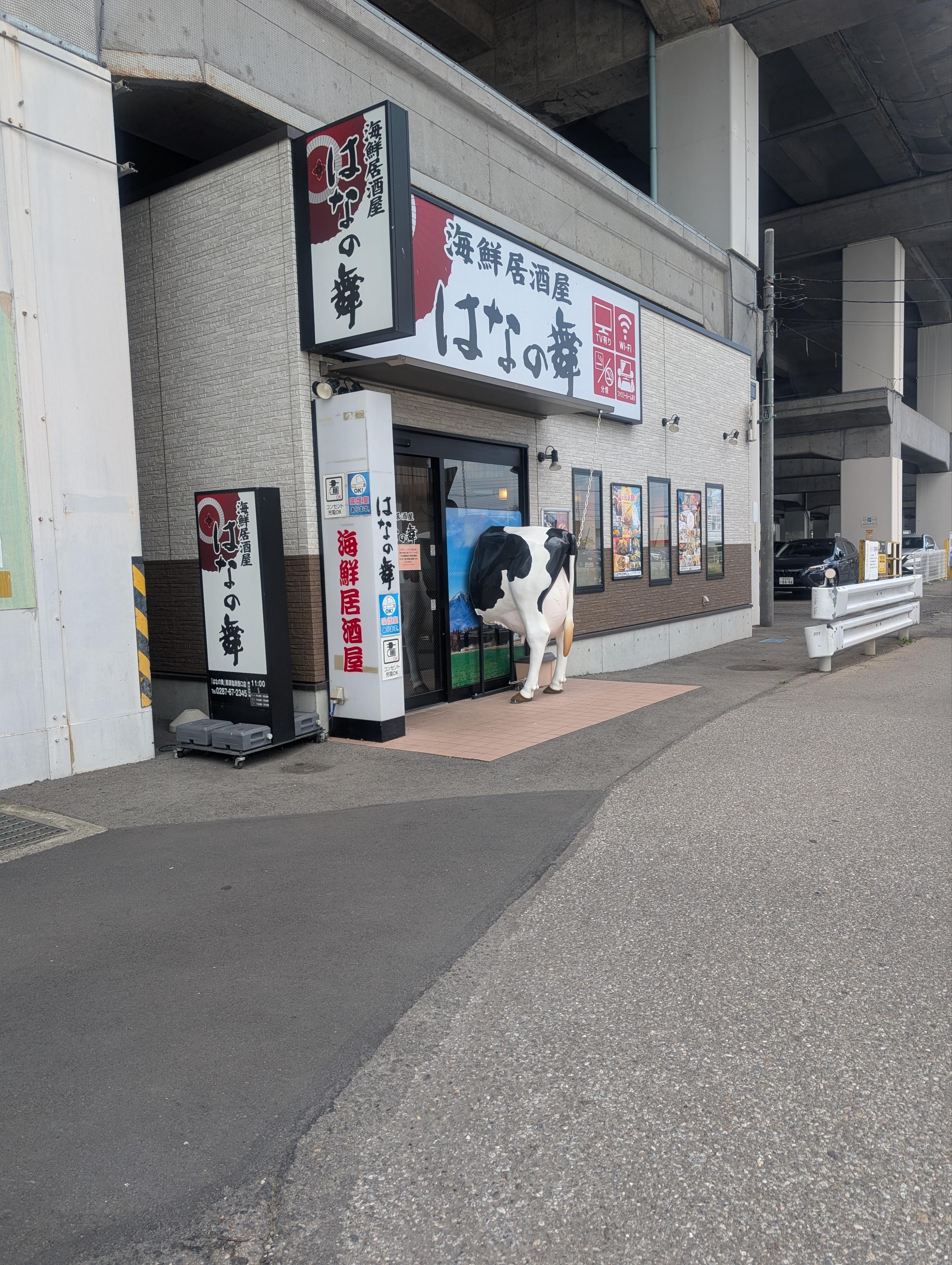 海鮮居酒屋の扉に牛が刺さっている