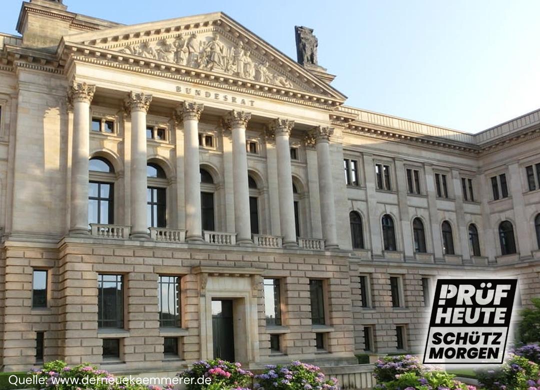 Du siehst die Fassade des Bundesrates in Berlin. Ganz deutlich ist der Haupteingang zu erkennen.
Unten rechts ist das Logo von PRÜF
"PRÜF
HEUTE
SCHÜTZ
MORGEN"
Das "P" von PRÜF besteht aus einem Ausrufezeichen und einem passenden Bogen am oberen Ende.
