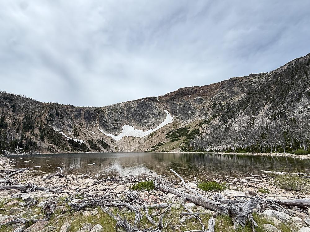 A glacial lake in the bowl of rocky, snow-patched mountains
