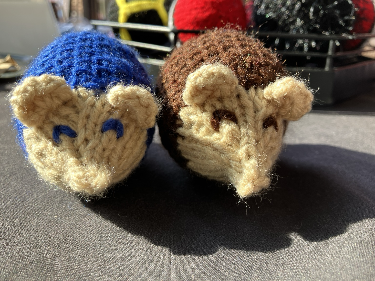 2 knit plush hedgehogs. One is blue and one is brown