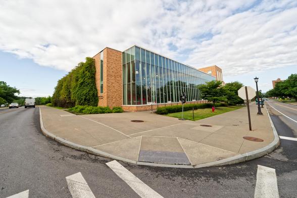 Wide angle view of building with glass and steel front and brick sides.