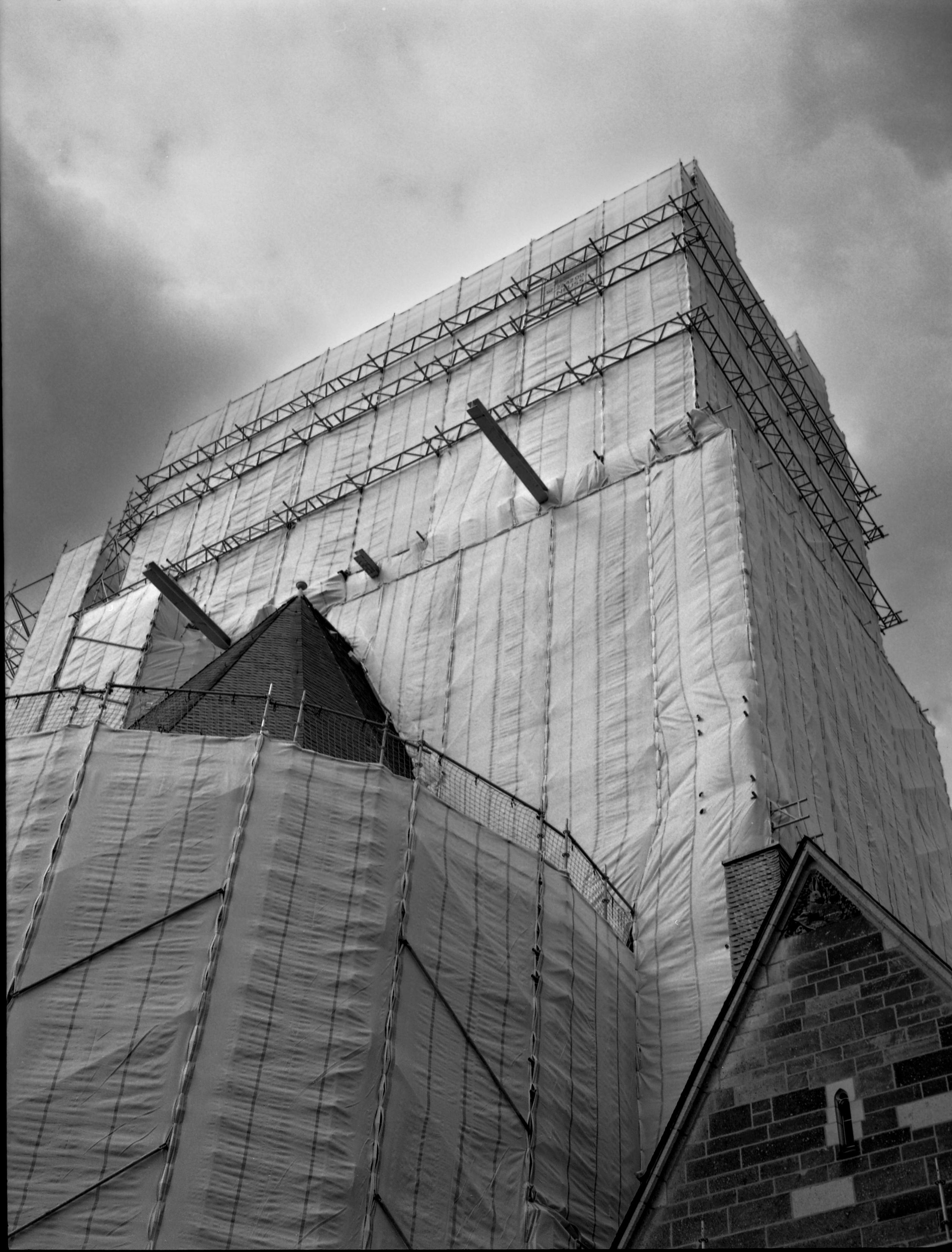 Blick nach oben an einem komplett mit Baupläne verdeckten Kirchengebäude