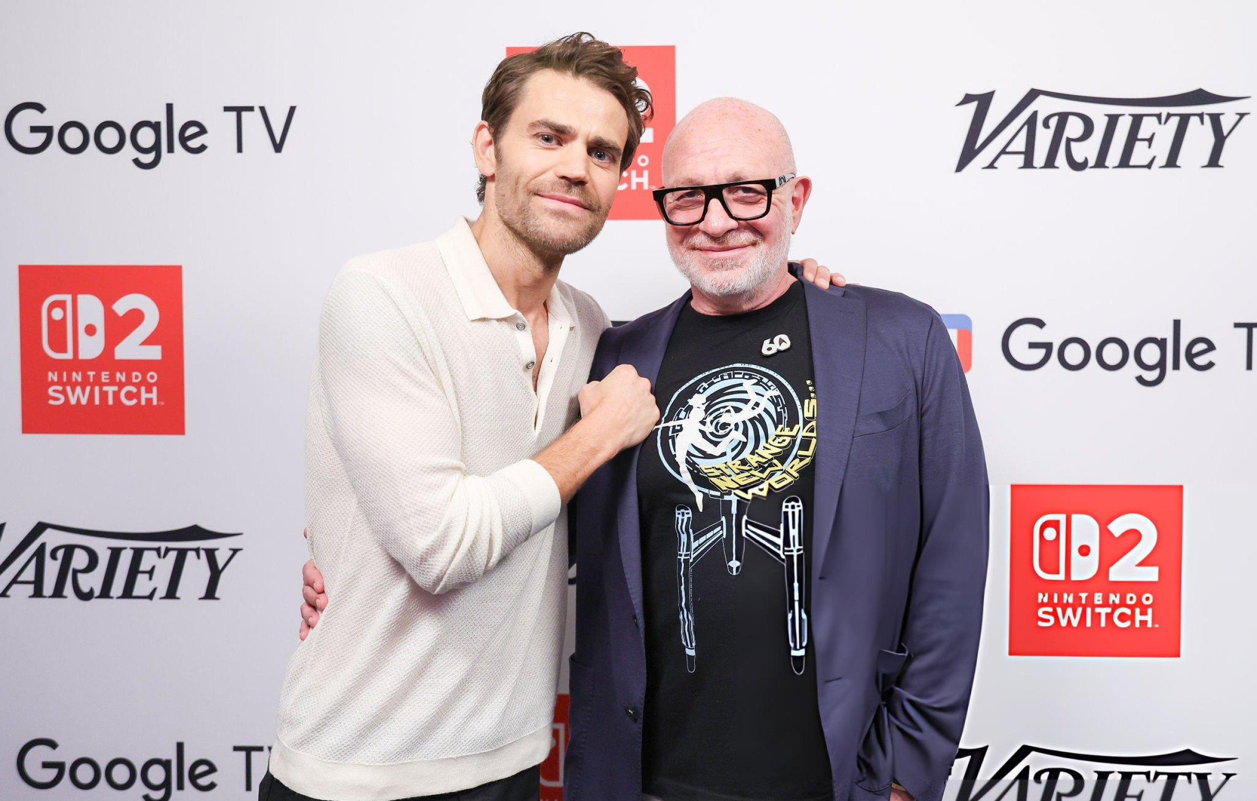 Paul Wesley with Akiva Goldsman at "Variety Studio" at SDCC: Paul wears black pants and a white jumper. Akiva wears beige trousers, a dark blue jacket and a black Star Trek fan shirt with the Enterprise on it + black framed glasses.