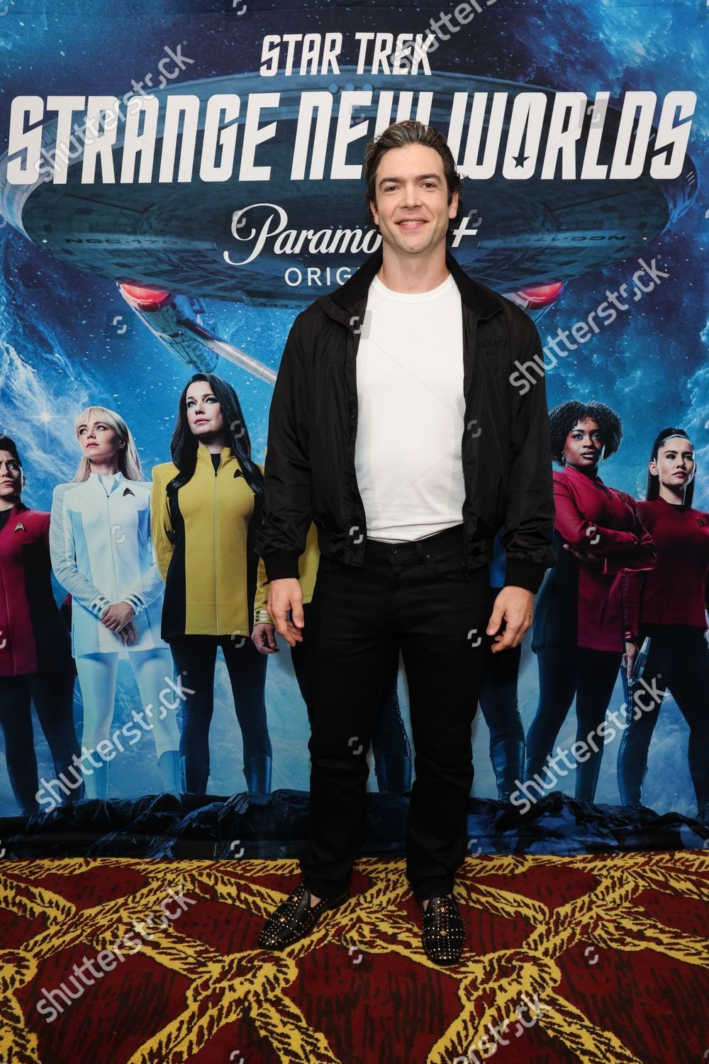 Ethan Peck at the Screening of SNW episodes 401 + 402 at SDCC. He wears black pants, a white t-shirt and a black jacket.