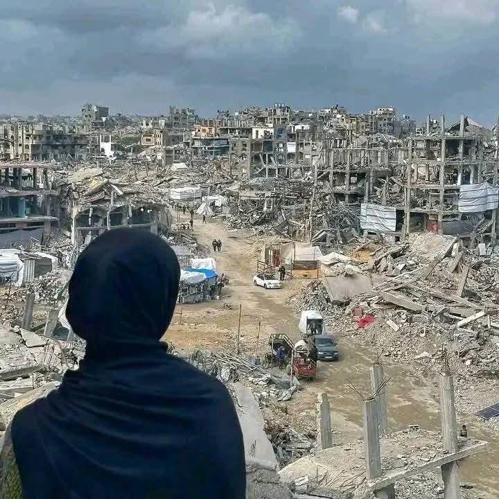 A girl in front of destroyed buildings in Gaza