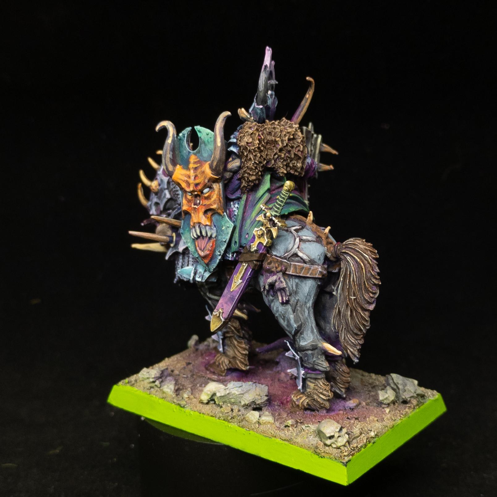 Chaos Lord in grey and blue armour, with a green shield, purple scabbard, on a steed in the grey and gold armour. Rear shot.