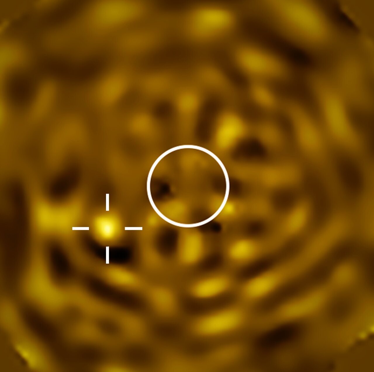 A telescopic image of Betelgeuse’s companion. The image is filled with a noisy pattern of bright and dark features, but there is a particularly bright object towards the lower-left. A white circle at the centre of the image indicates the size of Betelgeuse, which has been removed. 