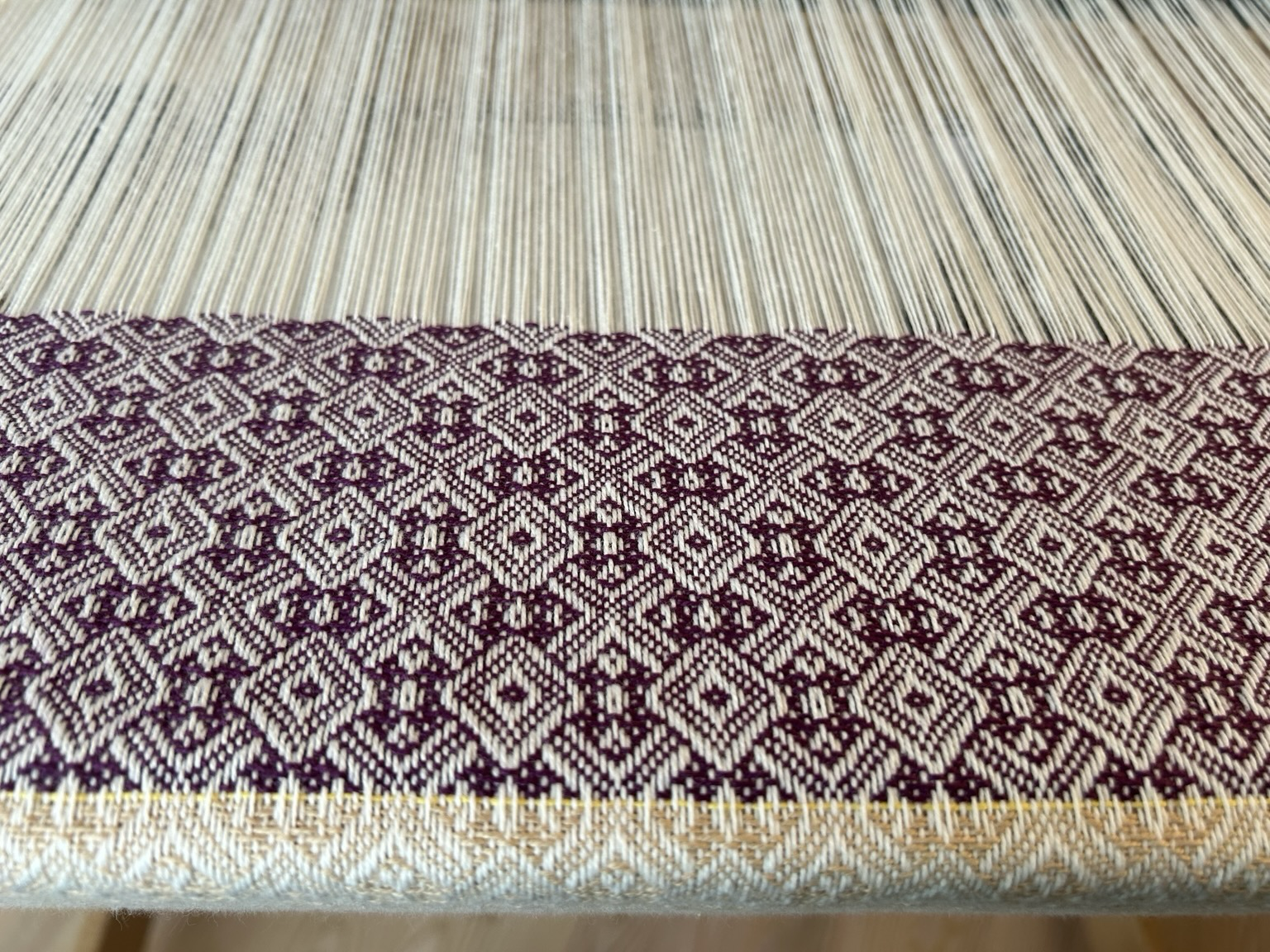 Complex twill in deep purple in progress on a hand loom