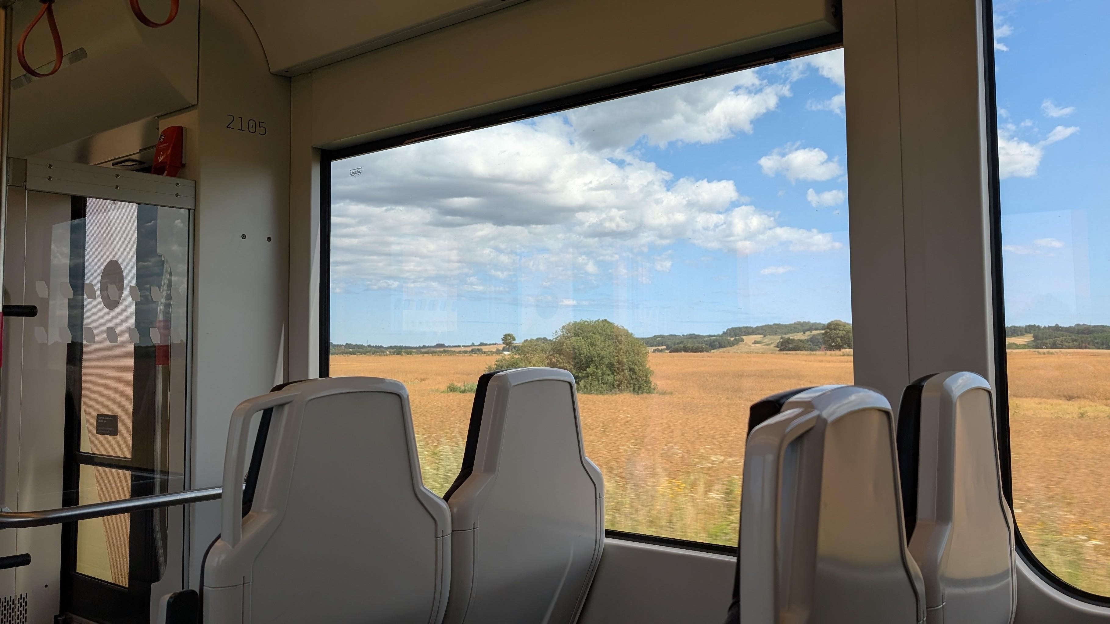 2 plus 2 seats behind each other, white plastic seat shell, almost no padding, yellow cornfields and some bushes rolling by