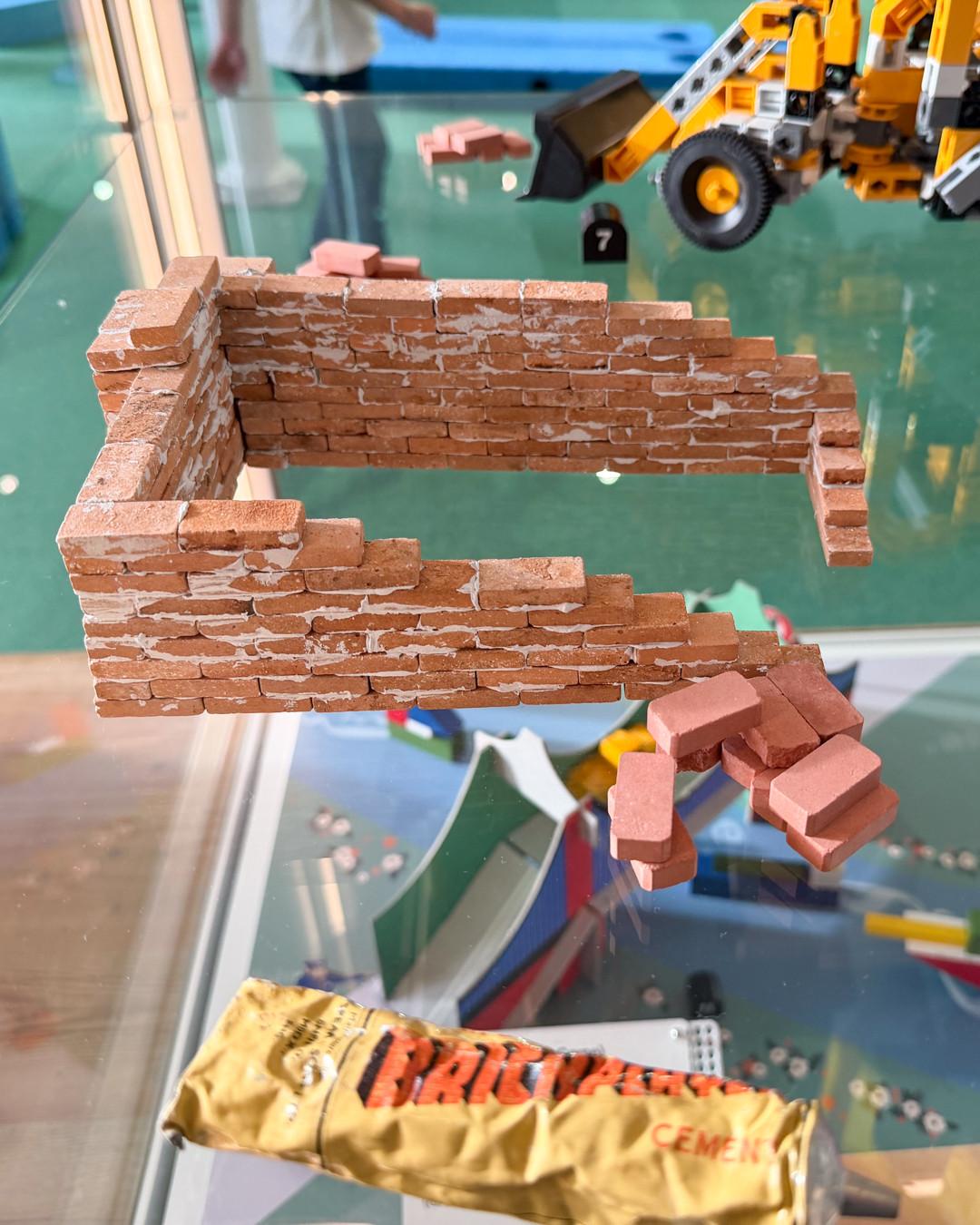 A museum exhibit displaying tiny bricks that have been cemented together.