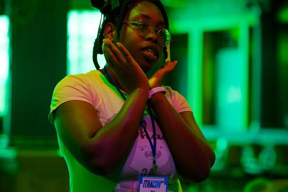 Black girl holds hands cutely around face with surreal green background