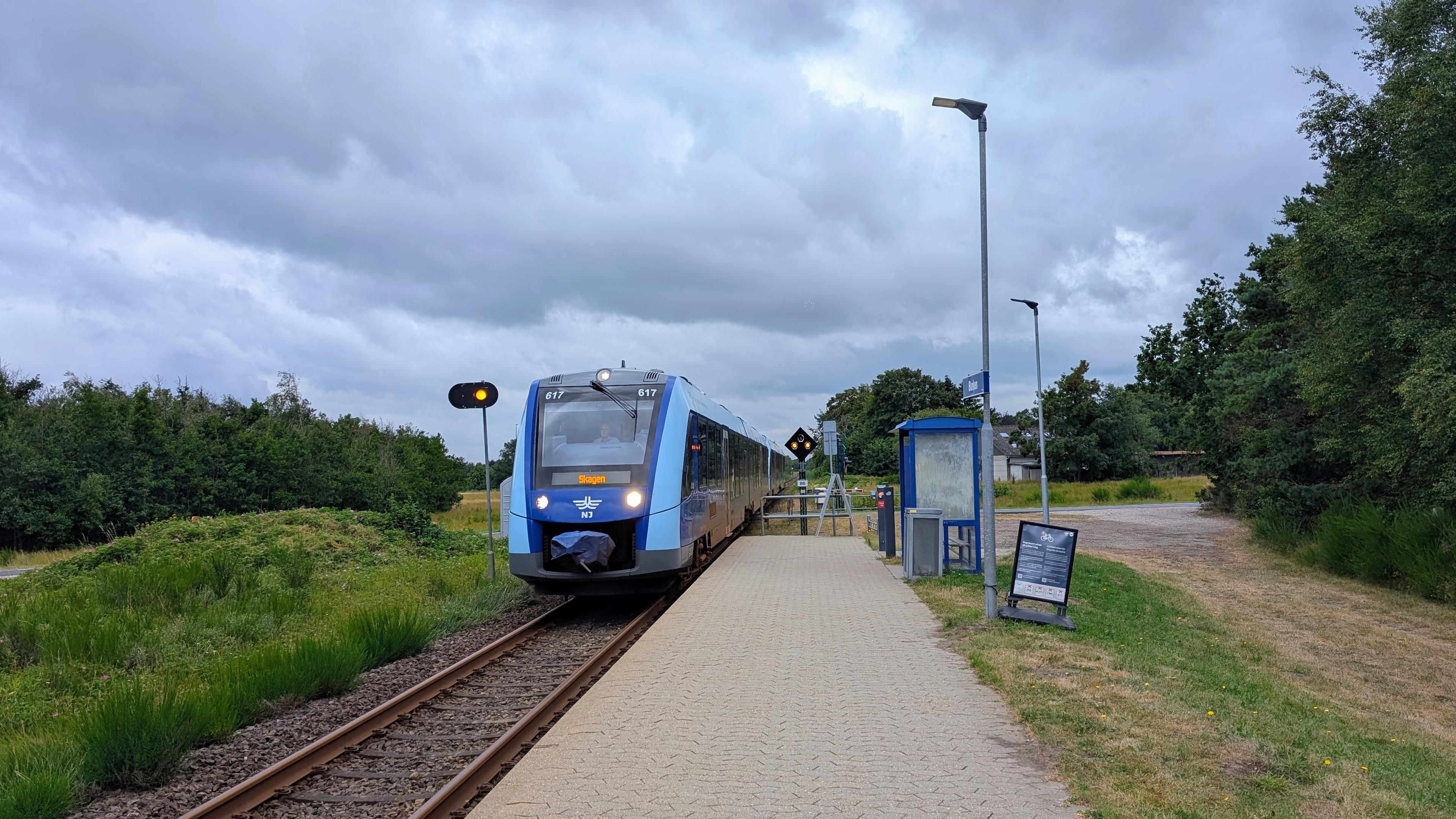 A train stop with a tiled platform and a small shelter, sign "Bunken", arriving NJ LINT 41 DMU at platform