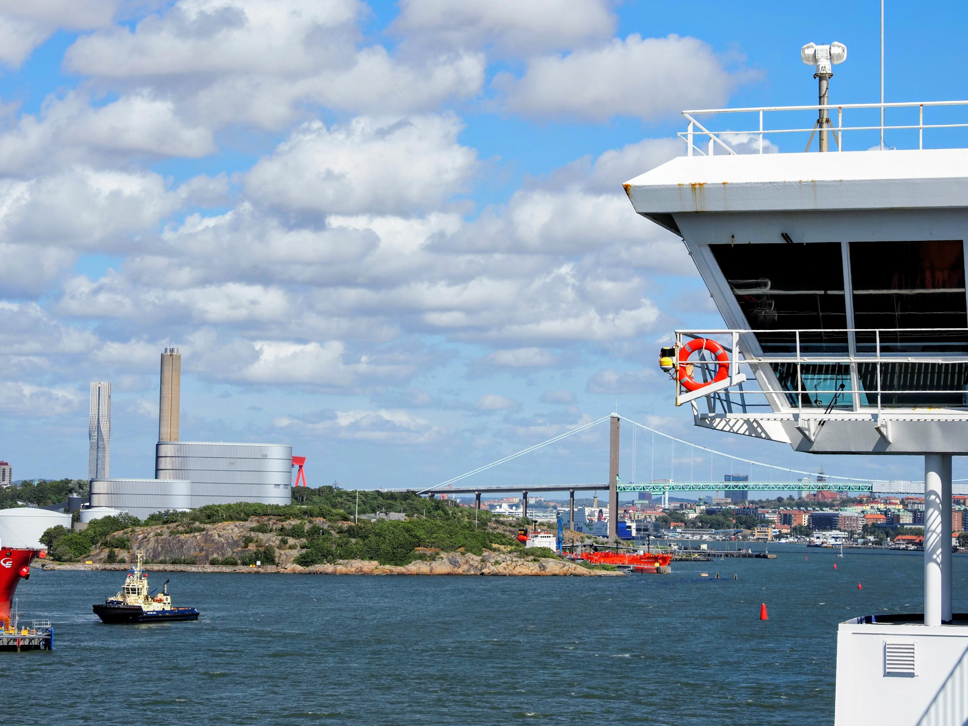 Protruding command deck, Älvsborgsbron crossing the body of water, Göteborg's center behind it, some ships on the water