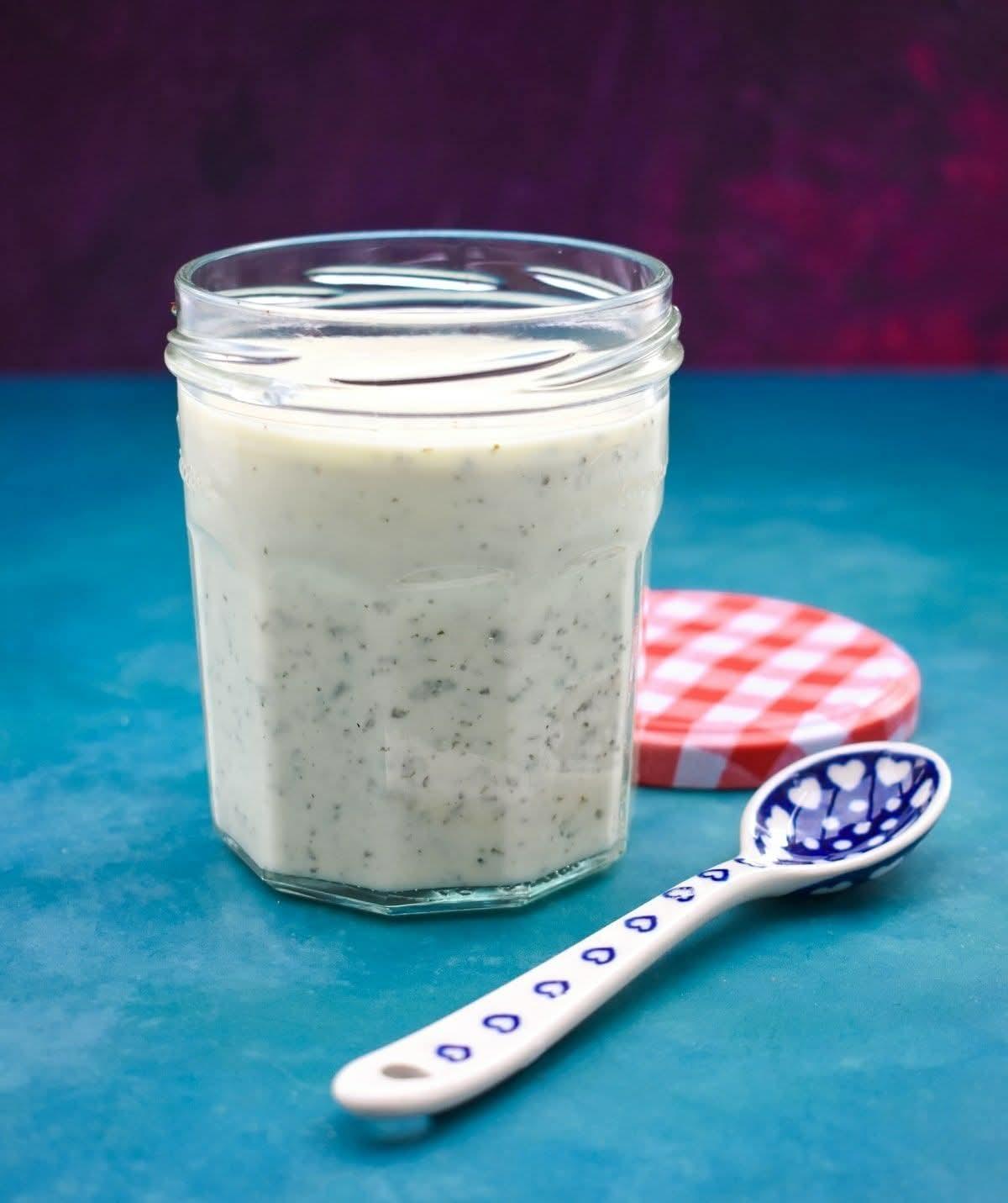 Jar of creamy Greek style vegan feta salad dressing.