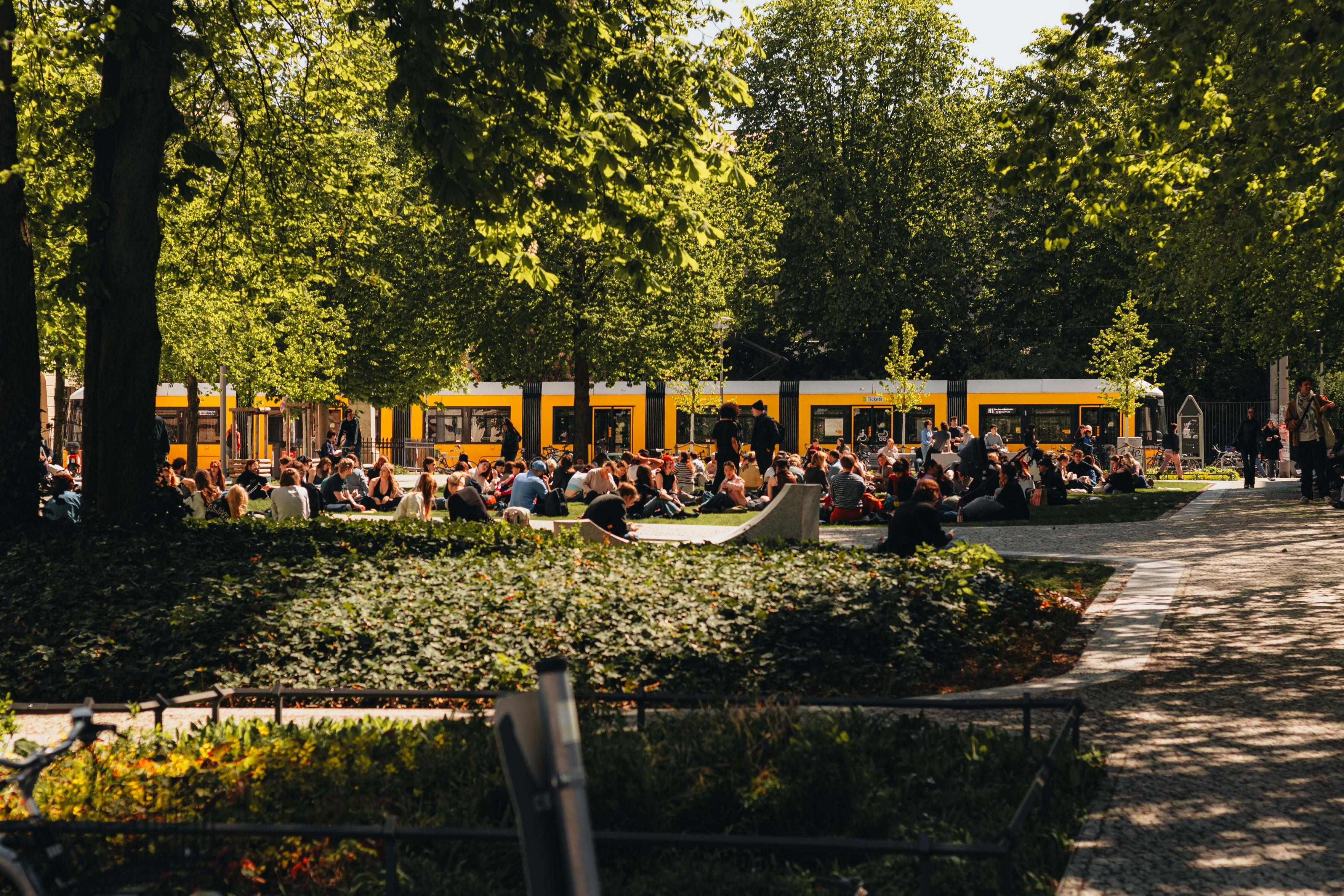 Gelbe Straßenbahn in einem Park mit Menschen und Bäumen. Foto: Airlind Photography, unsplash.com