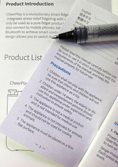 Photo of two random gadget manual pages, with the tip of a ballpoint pen for scale. Judging by the ballpoint pen, the type size on the manuals is 4 - 6 points.