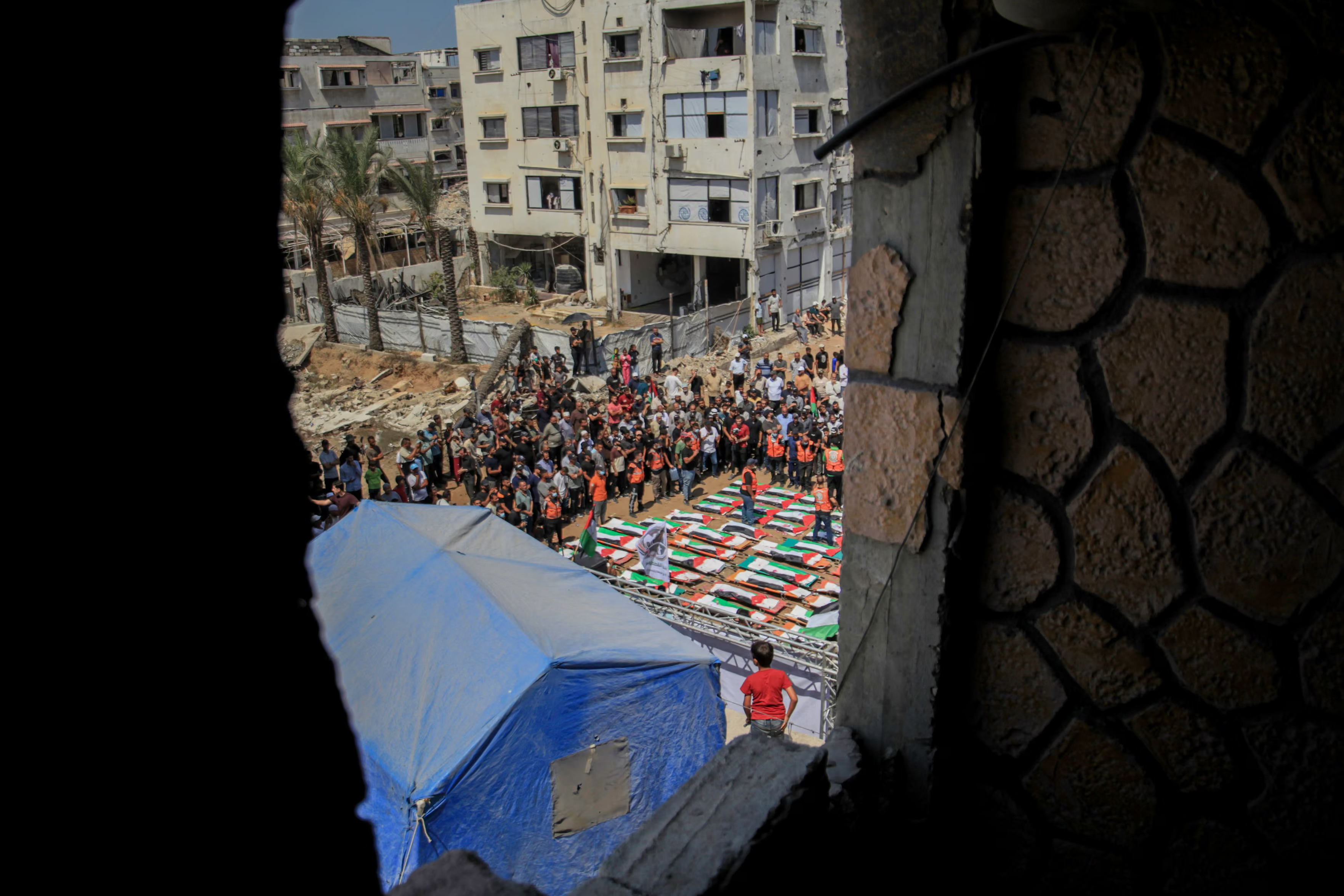 People attend a funeral ceremony for 112 members of two extended families.