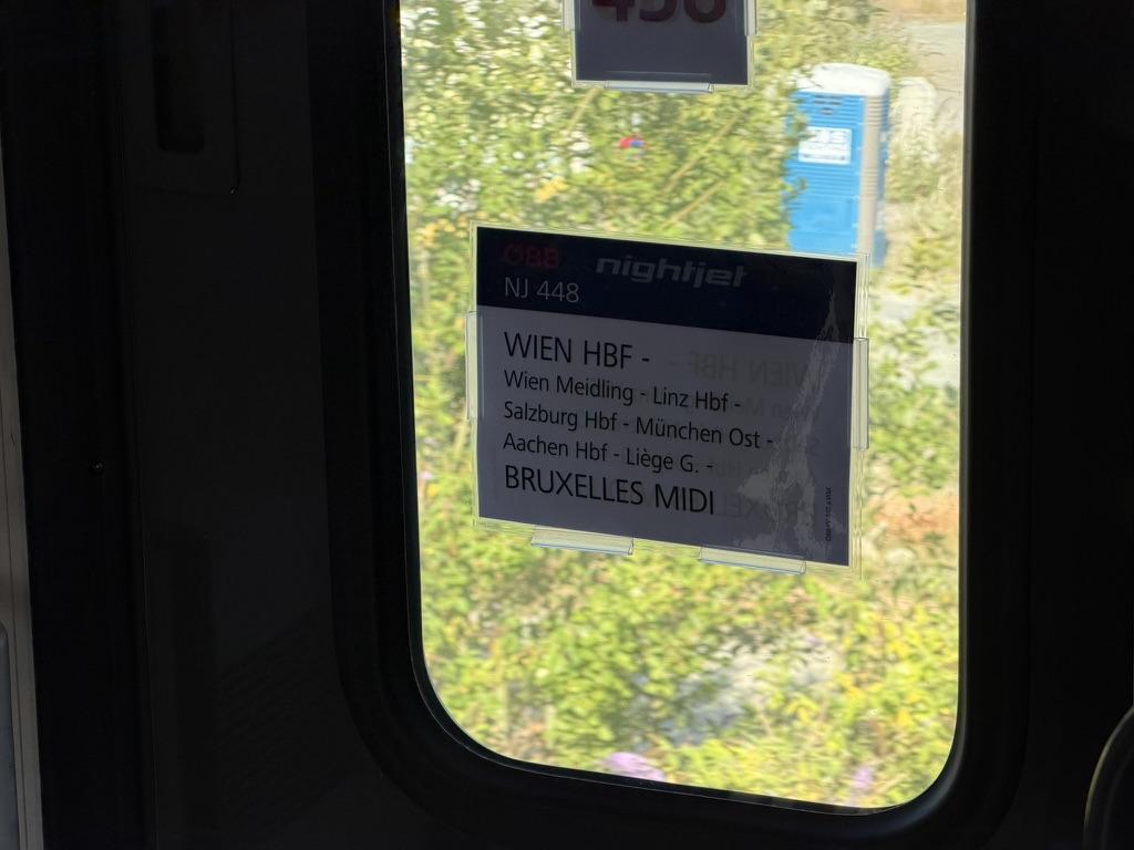 Nightjet itinerary on a piece of paper, pasted on the train wagon window: from Wien Hbf to Bruxelles Midi.