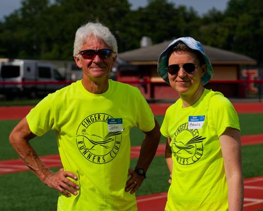 Man with white hair and and woman with ligh blue hat are both wearing yellow FLRC volunteer T-Shirts