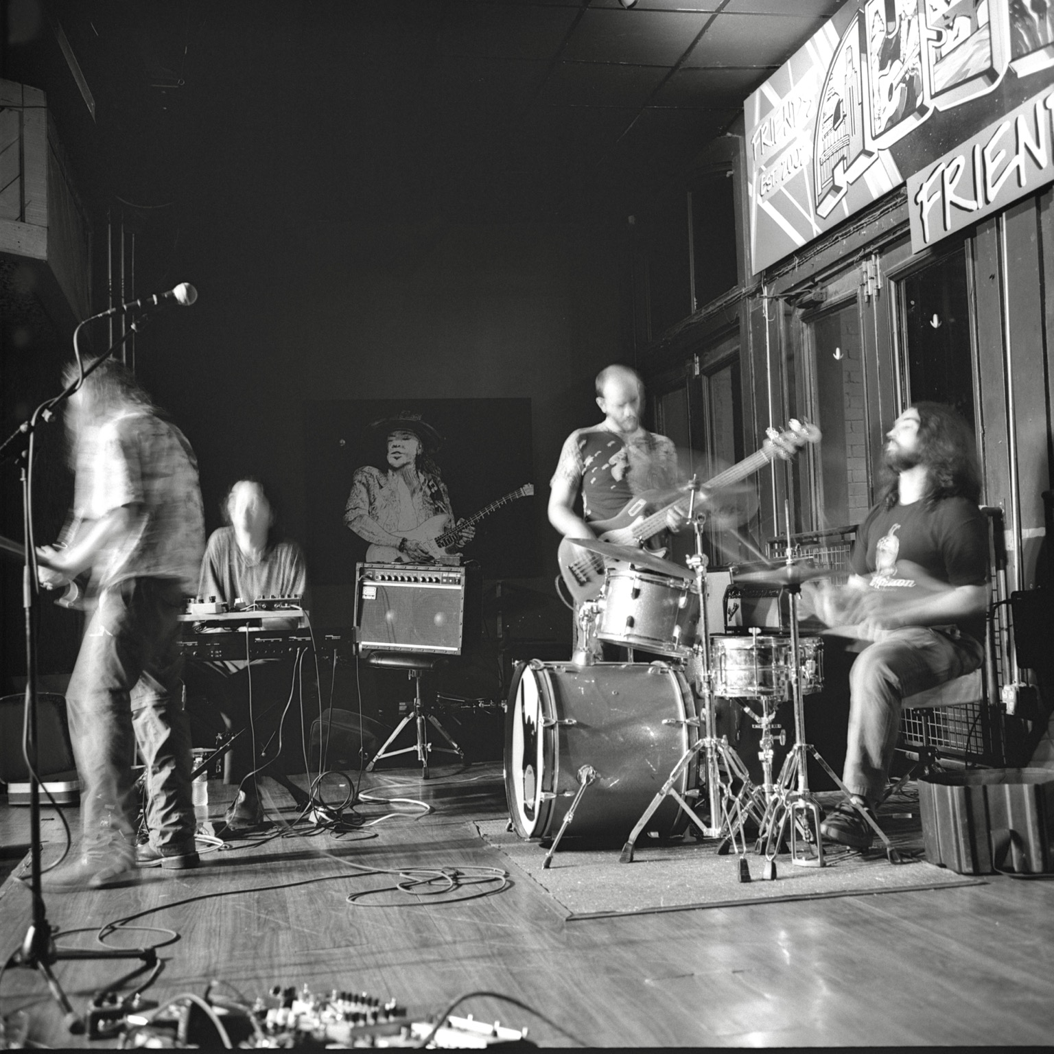 A black-and-white film photo. The band, Hunter Walkup, is seen playing live with motion blur at Friends in downtown Austin, Texas. Tuesday, July 28, 2026.