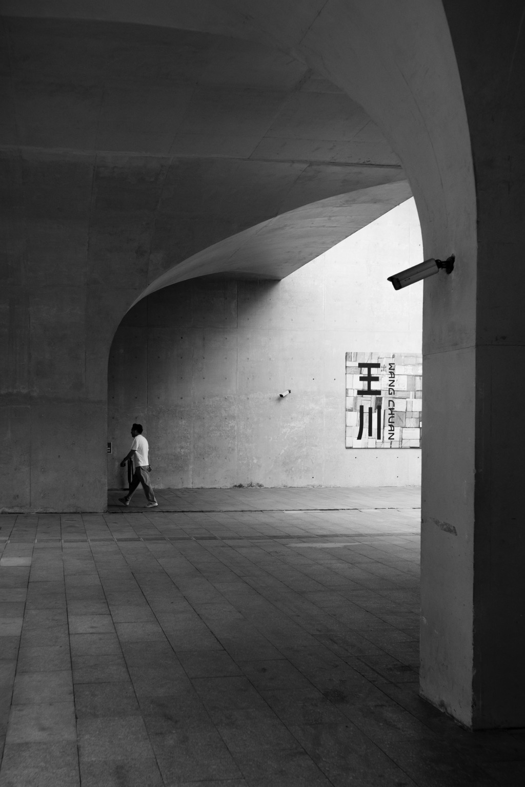 A man walks away from an always observant camera.