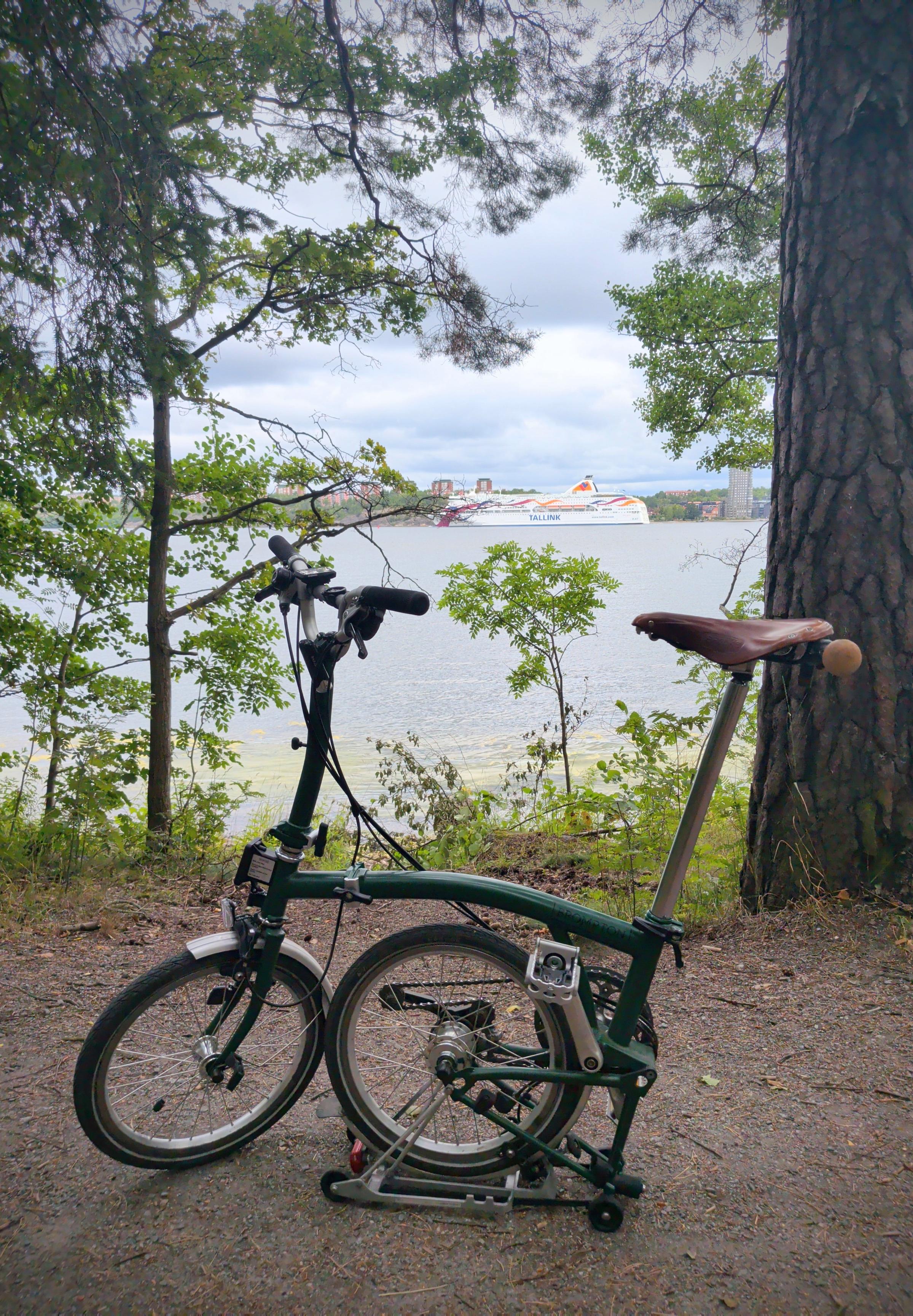 A folding bike in the foreground. The Baltic Sea with a ferry in the background