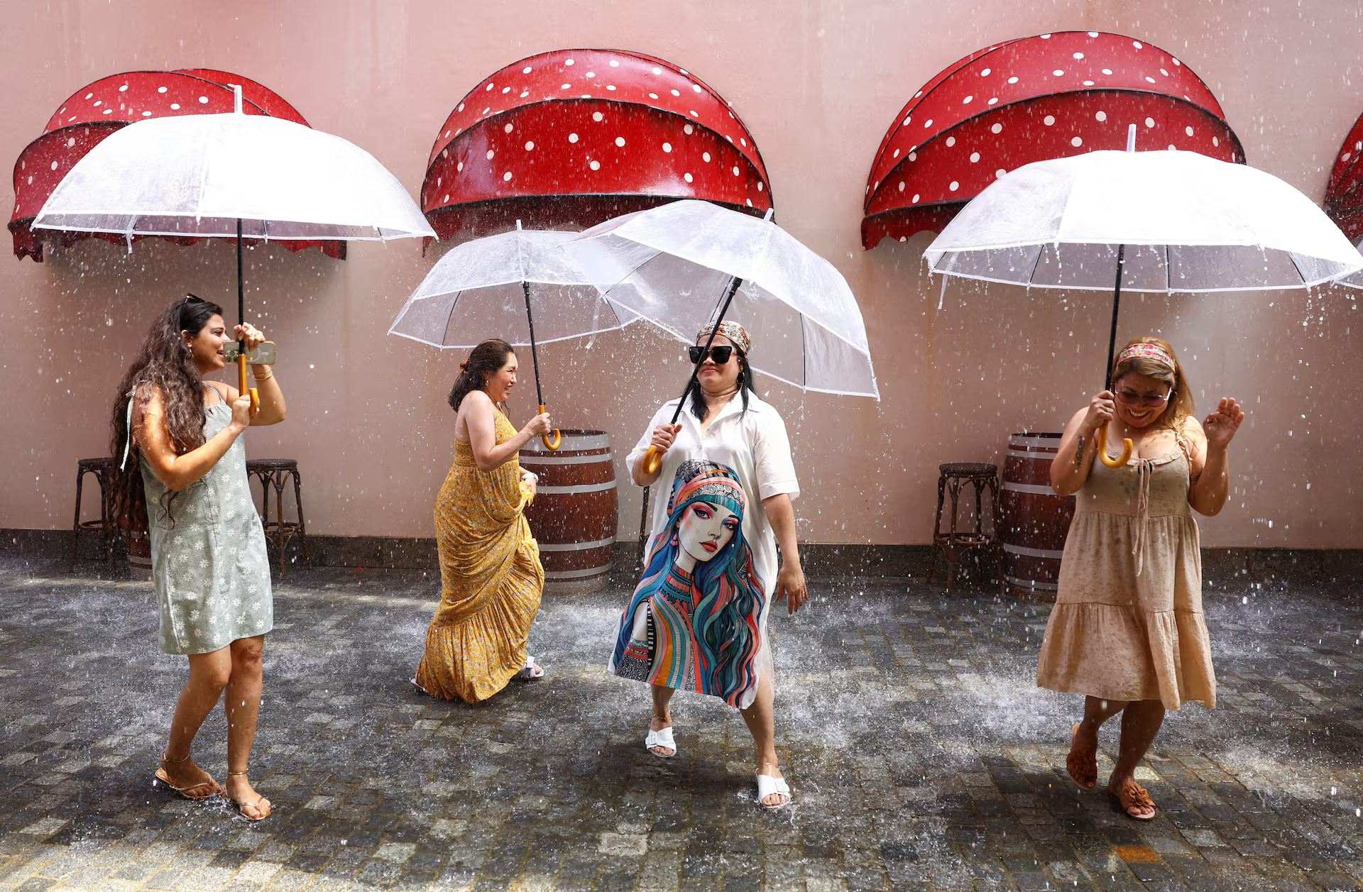 Women dance with umbrellas on a climate-controlled “rainy street".