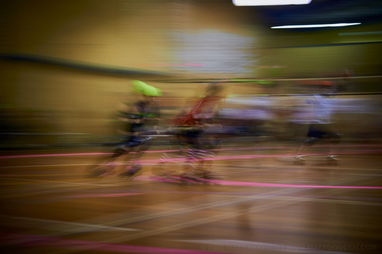A long exposure image of roller derby competitors from the D'Viants (lime green), and the Screaming Assault Sirens (red). 2013/11/09