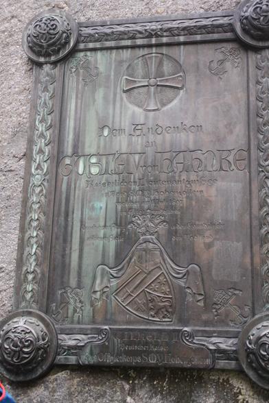 Rechteckige (hochkant), bronzene Gedenktafel mit Verzierungen/Insignien und folgender Inschrift:

Dem Andenken an 
Gustav von Hahnke
kaiserlichen Lieutenant zur See
an Bord der S.M.Y. Hohenzollern
welcher am 11. Juli 1897
im Alter von 26 Jahren
durch einen Sturz in den Grönsdalselv
an dieser Stelle den Tod fand

Wilhelm II
Deutscher Kaiser
u. das Offizierskorps der S.M.Y. Hohenzollern
