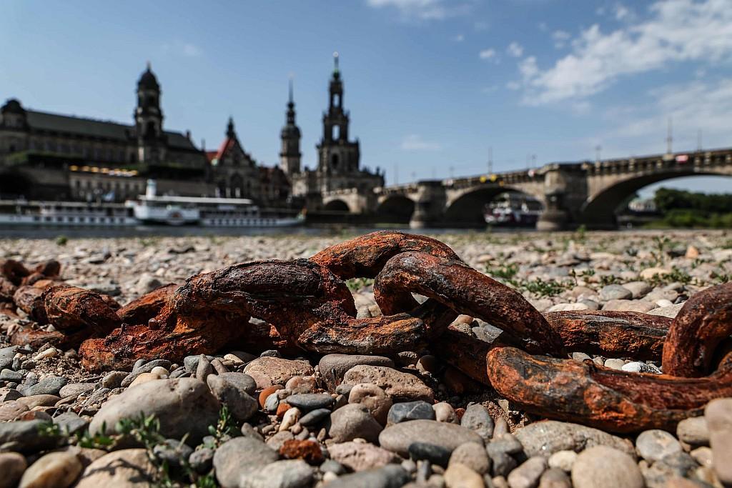 The dried-out Elbe riverbed in central Dresden, with rusted chains in the foreground.