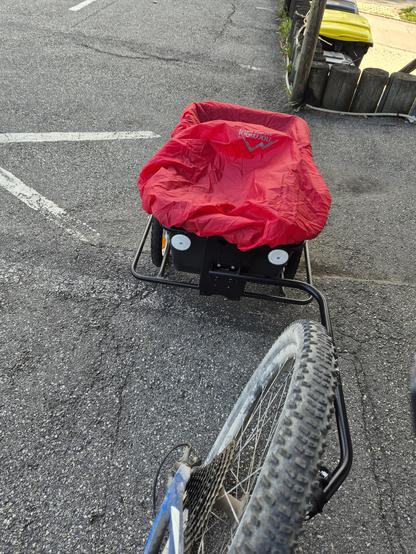 Picture showing a rear wheel and a little bike trailer mounted to the wheel