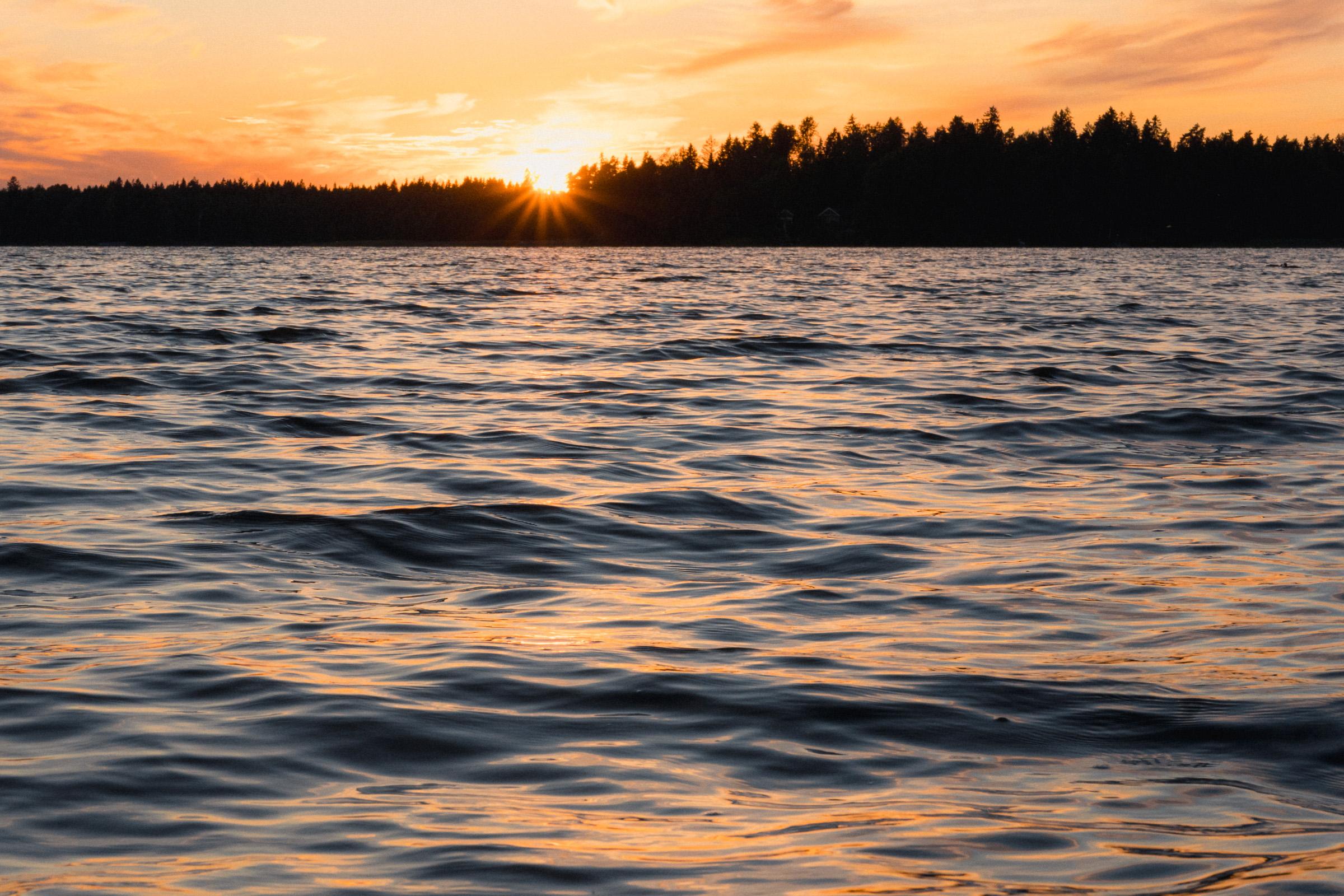 Tiefstehende Sonne über Wellen auf dem See