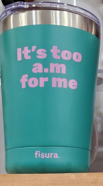 A green travel tumbler imprinted with pink text reading with "it's too a.m for me"