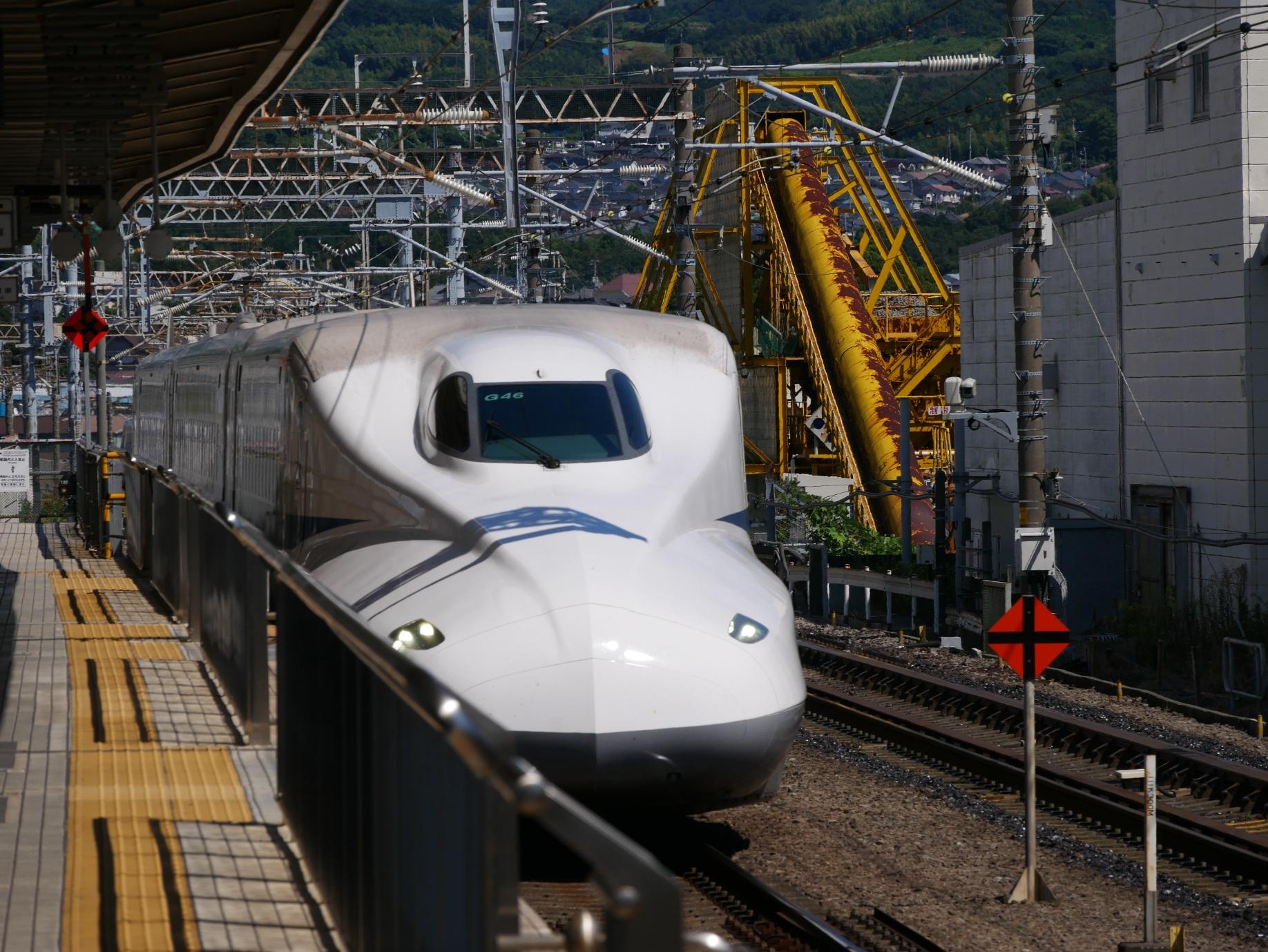 Shinkansen bei der Einfahrt in einen Bahnhof in Japan. Die gelben Flächen auf dem Bahnsteig markieren die  Einstiege. Der Zug ist super pünktlich, schnell und zuverlässig und an den Bahnsteigen gibt es den weltbesten Automatenkaffee. Japan 2024