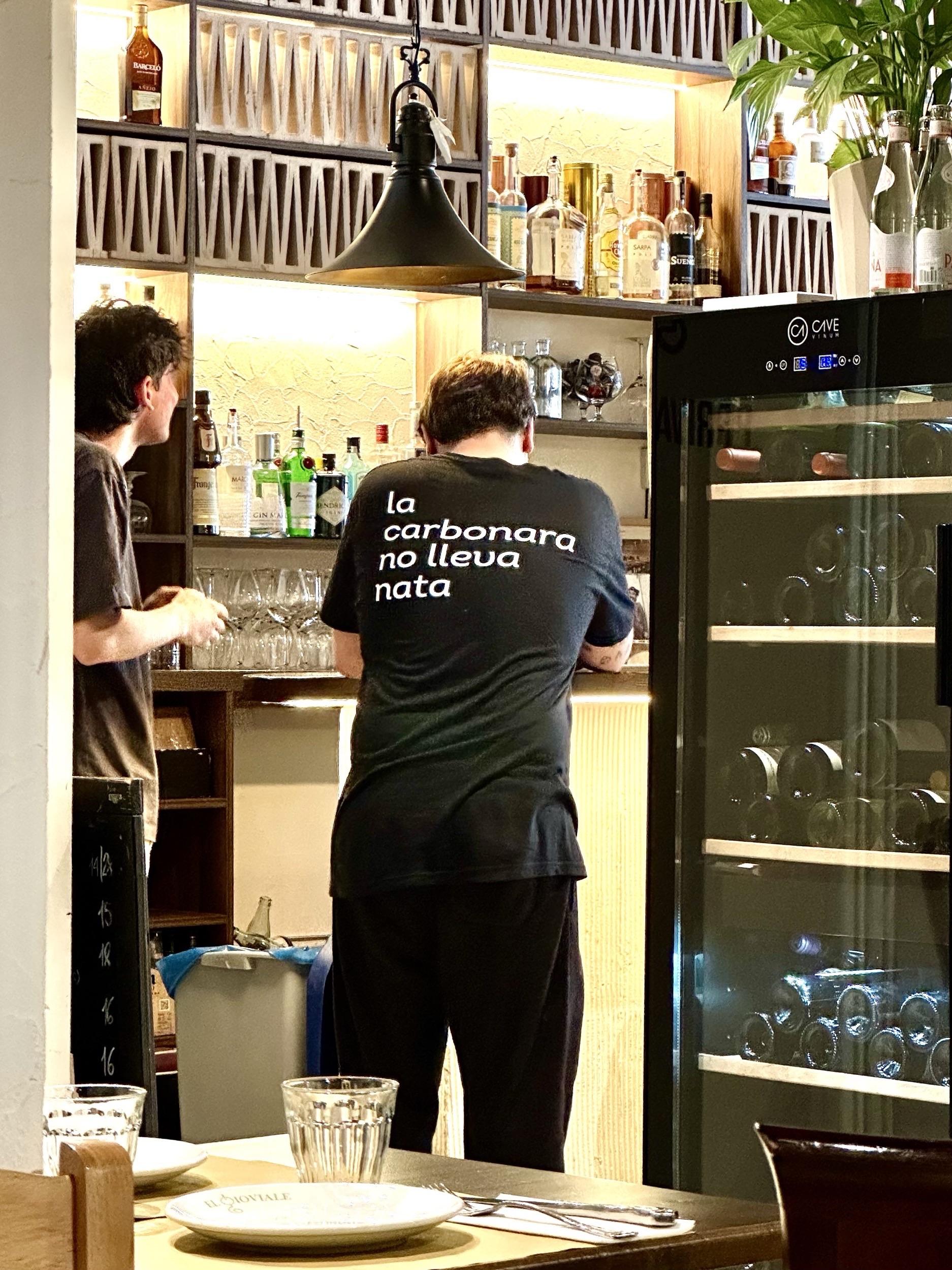 Camiseta con el mensaje “La carbonara no lleva nata” de un camarero en un restaurante italiano.