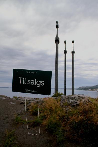 Stavanger, „Sverd i fjell“ = „Schwerter im Felsen“. 3 riesige Eisenschwerter stecken senkrecht nebeneinander im Fels direkt an der Küste. Davor besagtes Schild „Til salgs“.