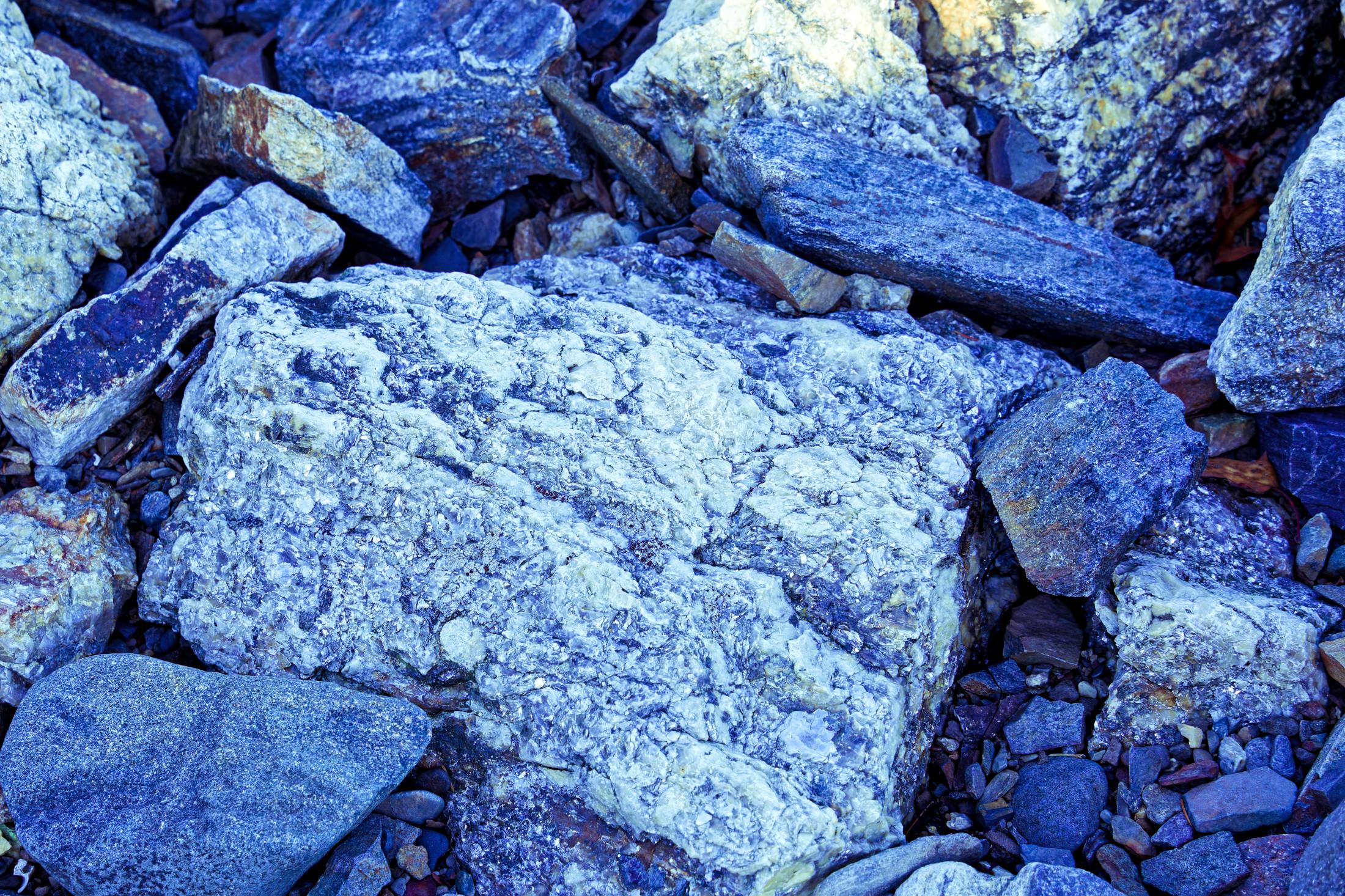 Boulders of Granite by seashore with crystal boundaries etched by weathering by the waves
