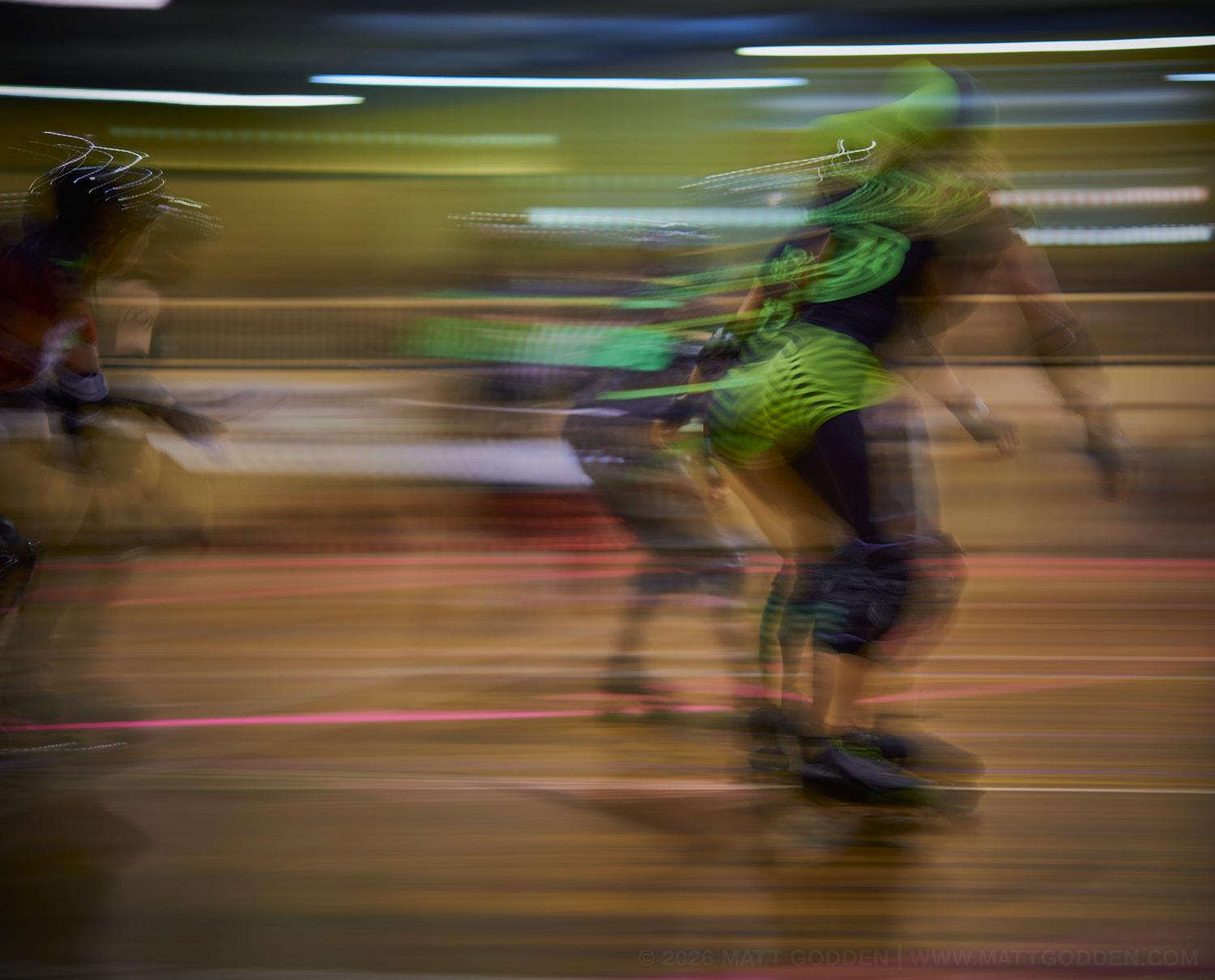 A long exposure image of roller derby competitors from the D'Viants (lime green), and the Screaming Assault Sirens (red). 2013/11/09