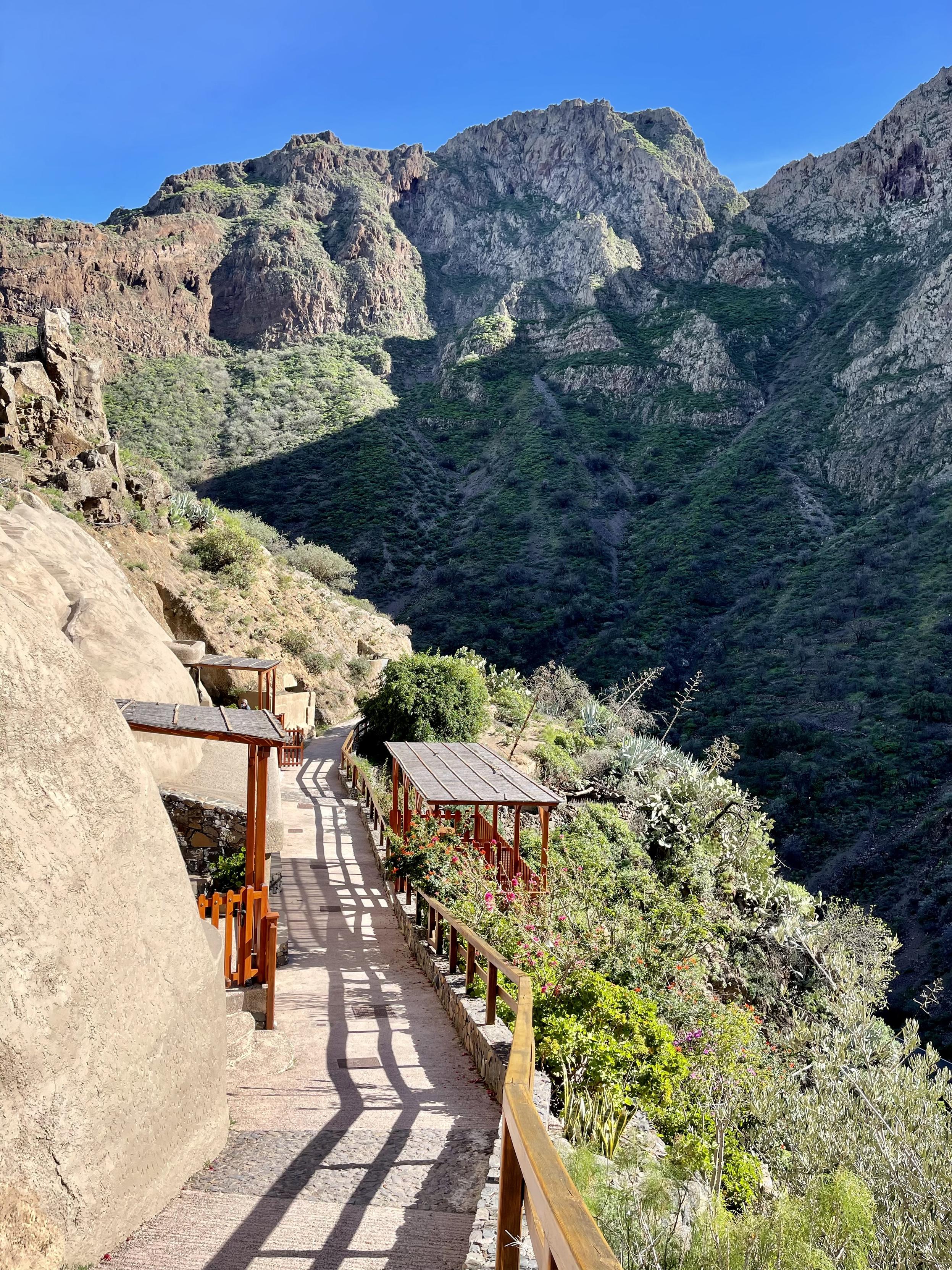 I’m not too sure whether this snap shot would qualify for #FootPathFriday, perhaps it does, but it’s definitely fit for #MountainMonday, so here we go. A gorgeous picture of the mighty mountains at Guayadeque on a typical winter day 😍👍🏻

You can see a small footpath you can walk into to find accommodation in some rural touristic homes facing the mighty mountains from Barranco de Guayadeque. There is a cosy wooden balcony as well on the right side of the picture, facing the mountains, providing one of those views that’s not easy to forget. On the contrary, what a breath-taking view?!?! 🥰👍🏻

This spot is part of one of my favourite winter hikes in the island. An exuberant lush of green blending in nicely with the mountain range and some cave houses on the left house for those who may fancy a unique experience. Oooh, and plenty of peace and quiet, too! What’s not to love, eh? 👌🏻😅