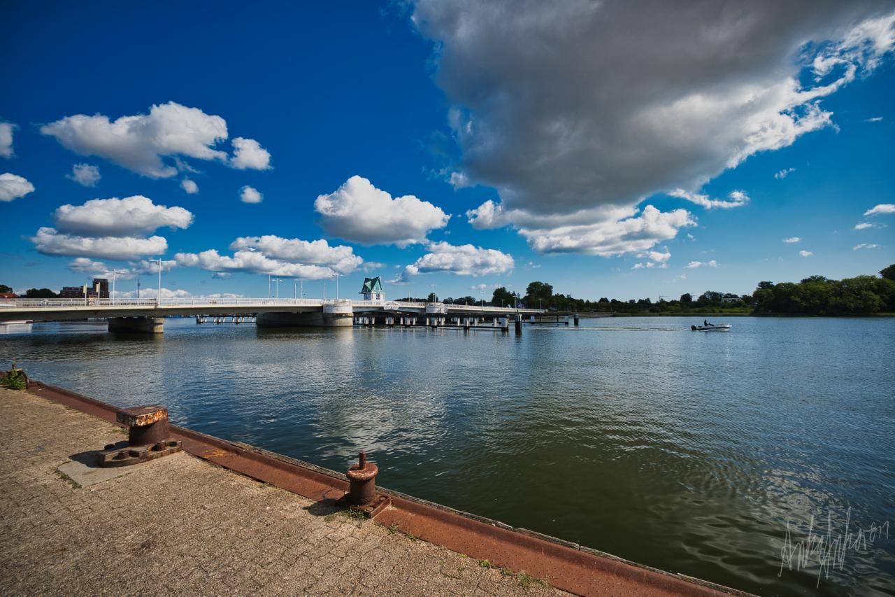 Die Schleibrücke in Kappeln mit einem Motorboot auf dem Wasser und Anlegepollern im Vordergrund